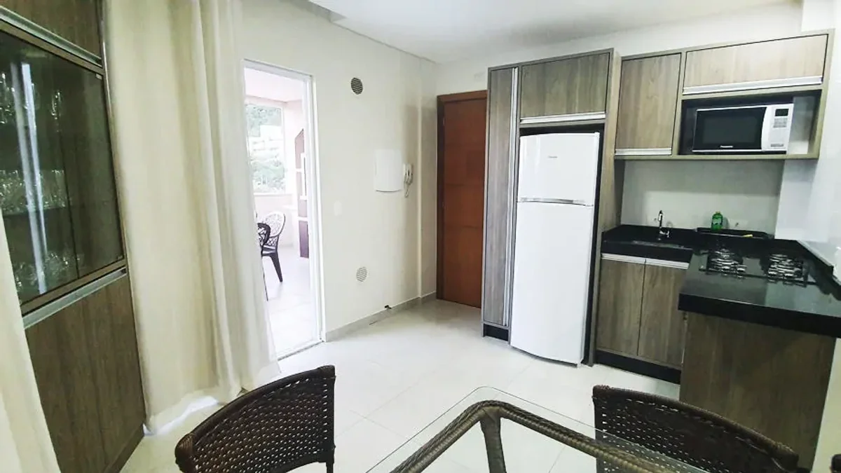 Sala da Cobertura 301 com sofá-cama, TV e mesa para 6 pessoas